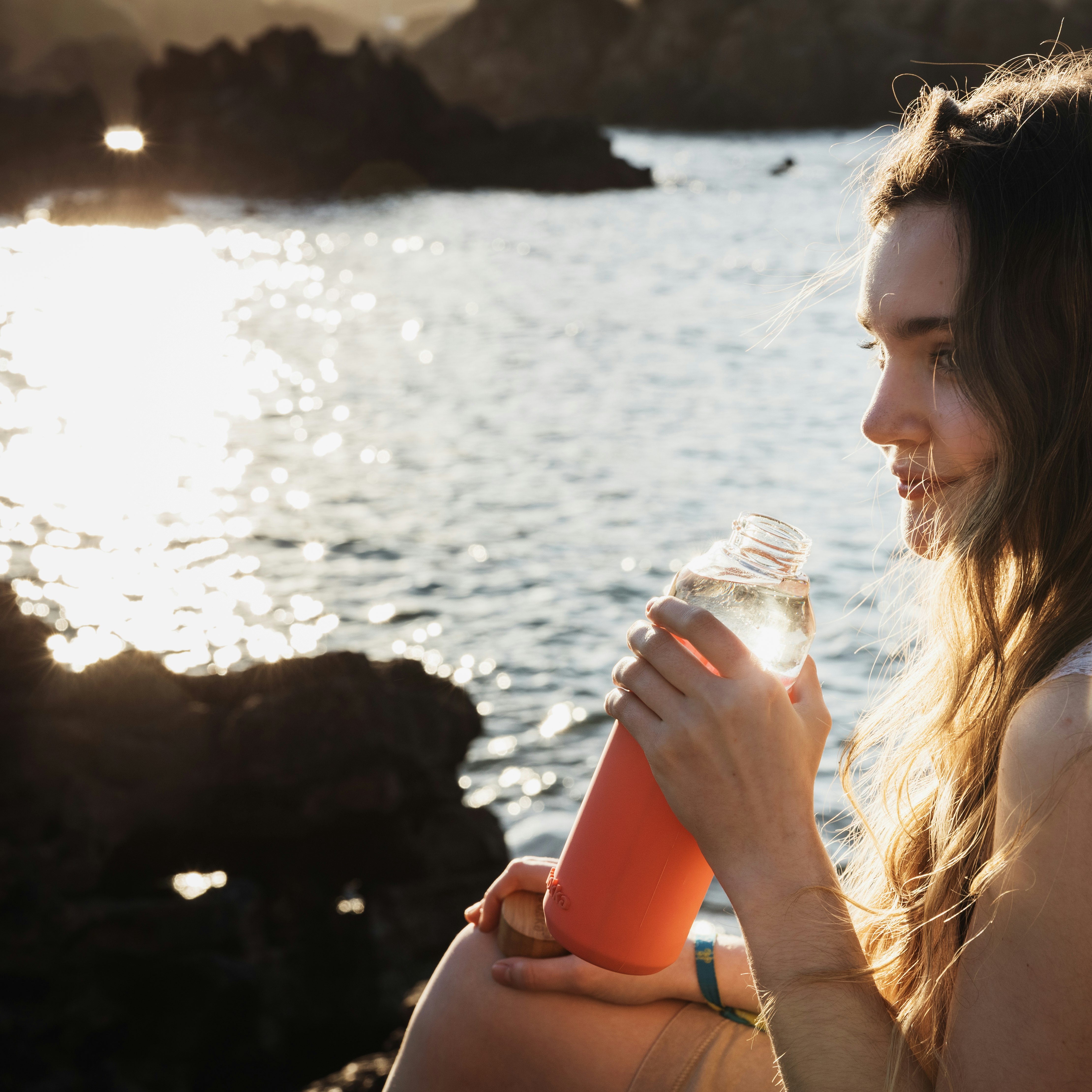 woman drinking water from clear plastic bottle